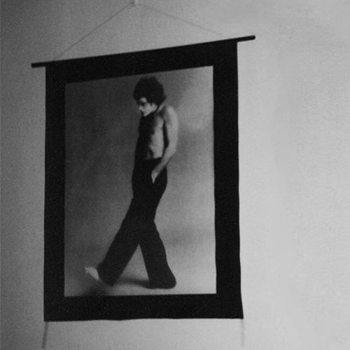 A character (Renowned Australian performing artist, Reg Livermore), downcast, with his hands in his trouser pockets walks downstage toward darkness. Photographer unknown